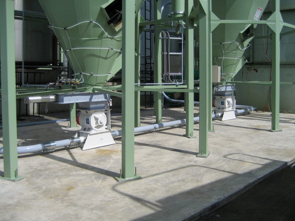 Industrielle Anlage mit grünen Silos und Rohrleitungen